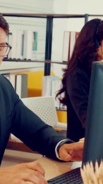 Ofiste çalışan kulaklık takan işadamları uzak müşteri ya da meslektaşlarını desteklemek için çalışıyorlar. Arama merkezi, tele pazarlama, müşteri destek acentesi telefon görüşmesinde hizmet sunar.