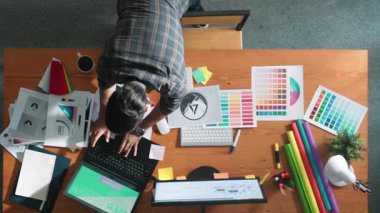 Kulaklıktan müzik dinlerken yetenekli iç dizayn grafiklerinin yukarıdan aşağı havadan görüntüsü. Proje yöneticisi kulaklıkla çalışırken ve rahat şarkılar dinlerken stüdyoda hareket ediyor. Sempozyum.