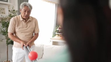 Yaşlı bir adam evde partneriyle top yuvarlama oyunu oynuyor, zihinsel ve fiziksel sağIık için el-göz koordinasyonu, odaklanma ve motor becerileri pratiği yapıyor. Sağlık hizmetleri konseptini engelliyor. Myrmidon.