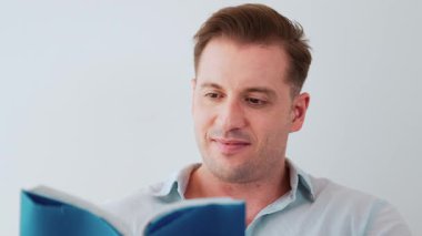 Kanepede oturan orta yaşlı bir adam, sosyal ve teknolojik mesleki gelişmeler hakkında ders kitabı okur ya da çocukları iyi bir yetişkin baba olmak için yetiştirir. Hayat boyu öğrenme konsepti. Uyumsuzluk.