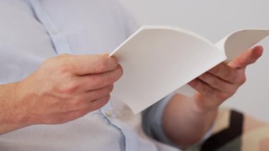 Kanepede oturan erkek, meslek büyümesi için ürün sunmak ya da iş değerini akıllı iş adamı olarak en yüksek noktaya çıkarmak için yaşam tarzı ve bilgi konseptine sahip bir defter ya da kitap hazırlar. Uyumsuzluk.