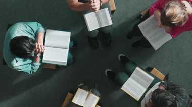 Yetenekli çeşitli dualar, el ele tutuşmalar ve daireler çizerek Tanrı 'ya dua etmeler. Kucaklarda açık incille otururken el ele tutuşan insanların yukarıdan aşağı hava görüntüsü. Sempozyum.