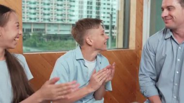 Gülümseyen çocuk grup terapisinde el çırparken mutlu öğretmen fikrine katılıyor. Liseli yetişkinler fikir paylaşırken farklı arkadaşlar sınıflarında oturup dikkatle dinliyorlar. Öğretim