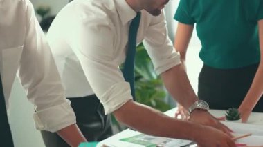 Akıllı iş adamlarının tasarımı planlamak için tabletten proje planına bakarken ve planlar ve toplantı masasındaki bina inşaatı hakkında tartışırken birlikte çalışması. Hizalama.