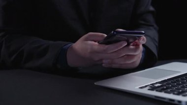 Bir kişi dijital güncelleme animasyonunu gösteren bir akıllı telefonla etkileşime girerken, bir dizüstü bilgisayar da modern yazılım güncelleme süreçlerini temsil eden bir teknoloji arayüzü gösterir. Dörtgen