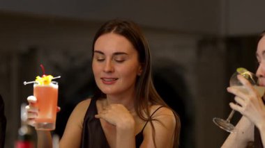 Paloma 'da fermuarlı kokteyl içen güzel bir kadın, limonlu ve vişneli menüyle süslenmiş, yanında lüks bir barda elinde Margarita bardağıyla serinletici bir içecek tutuyor. Vinosity.
