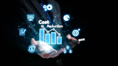 Bir çift el, işletme simgeleriyle çevrili, mali tasarrufları ve yönetimde stratejik planlamayı sembolize eden bir dijital maliyet azaltma tablosunu sergilemek için uzandı. Dörtgen