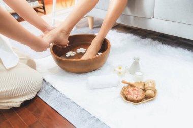 Kadınlar lüks spa salonlarında keyifli ayak masajlarına devam ederken, masör de hafif gün ışığı atmosferinde refleksoloji terapisi veya otel ayak spa 'sında. Sessiz.