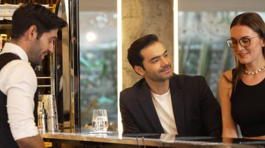 Güler yüzlü, VIP müşterileri içki tezgahında oturup barmenle konuştukları için davet eden ve ilk izlenimlerini harika yapan hoş geldin içkisi profesyonelliği hazırlayan çift. Vinosity.