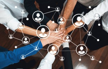 Bu resim ağ oluşturma ve işbirliği kavramını, takım çalışmasını ve birliği temsil eden dijital bir bağlantı grafiği içinde el ele tutuşmayı gösteriyor. Dostluk