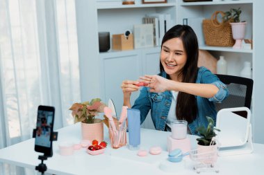 Genç, güzel Asyalı kozmetik makyaj ruju matte pastel rengini modern odadaki sosyal medyada kol testi tanıtımında en çok satanlar listesinde gösteriyor. Taktik.