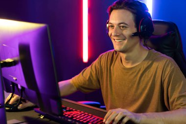 Kazanmak için çevrimiçi oyun oynayan akıllı flama makinesinin sunucu kanalı, neon ışıklı odada seçilen takım yarışması için izleyicilerle birlikte canlı yayında canlı yayında kulaklık takıyor. Bireysel.