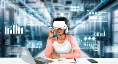 Masada kitap ve dizüstü bilgisayarla ödev yaparken metaevreleri birbirine bağlayan dizüstü bilgisayar ve artırılmış gözlük kullanan bir kız. Öğrenci holograma bakıyor ve yapay zekayı kullanıyor. Yaratıcılık.