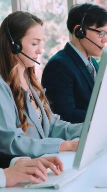 Ofiste çalışan kulaklık takan işadamları uzak müşteri ya da meslektaşlarını desteklemek için çalışıyorlar. Arama merkezi, tele pazarlama, müşteri destek acentesi telefon görüşmesinde hizmet sunar.