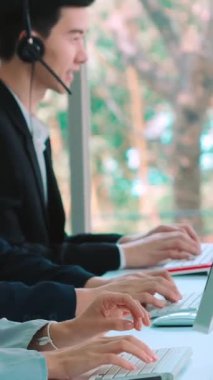 Ofiste çalışan kulaklık takan işadamları uzak müşteri ya da meslektaşlarını desteklemek için çalışıyorlar. Arama merkezi, tele pazarlama, müşteri destek acentesi telefon görüşmesinde hizmet sunar.