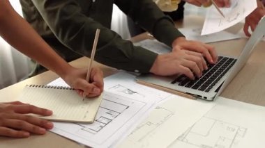 Modern ofiste doğruluk için mimari belge ya da plan ve ölçüm aracıyla birlikte dizüstü bilgisayarda mimari ayrıntılı planlama ve ölçüm projesine danışmanlık yapan mimar ve mühendis. - Yakın çekim. Tanımlama.