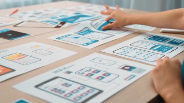 Mobil uygulama için kullanıcı arayüzü prototipi ya da masadaki program modeliyle birlikte web sitesi planlaması yapan bir şirket çalışanı. UX UI tasarımcısı kullanıcı dostu arayüz planını dikkate alır. Sinerjik