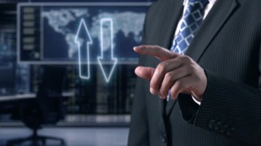 Bir işadamı dijital ekranın yanında duruyor, kalite ve maliyet ölçülerindeki değişiklikleri sembolize eden oklar sergiliyor ve modern bir çalışma alanındaki önemli iş kavramlarını gösteriyor. Dörtgen