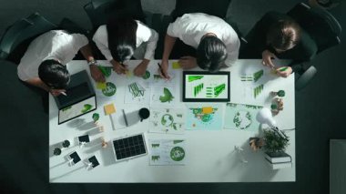 Yönetici yöneticisinin üst görünümü toplantılarda tablet temiz enerji gösterir. İş adamlarının sürdürülebilir çevre yatırımlarını planlamak ve yatırım yapmak için birlikte çalıştıklarına dair havadan bir bakış açısı. Hizalama.