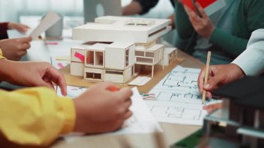 Modern bir çalışma alanında aktif olarak işbirliği yapan profesyonellerin yaratıcılık ve yenilikleri desteklediği ayrıntılı bir model ve planların yer aldığı dinamik bir mimari tasarım oturumu. SACTR