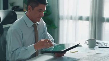 Profesyonel mühendis, türbin motoru veya jet motoru tasarımı ve çeşitli metal teçhizat dağılımı ile toplantı masasında yeşil ekranlı tablet üzerinde çalışırken telefona bakıyor. Hizalama.