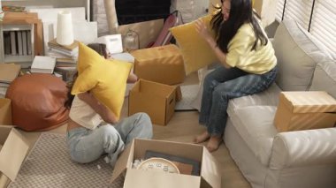 Taşındığı gün yastık savaşı oynarken oynayıp vakit geçiren mutlu lezbiyen sevgili. Çekici oda arkadaşı yastığı tutarken arkadaşı kanepede, diğeri de yerde oturuyor. Myrmidon.