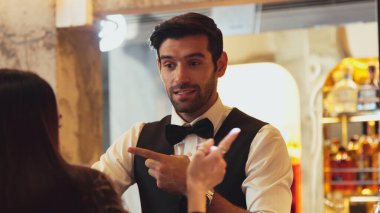 Gülümseyen zeki barmen, gece kulübünde VIP müşterilerle canlı sohbetler yapmak için güzel bir gece partisi atmosferine mükemmel bir servis sunuyor. Vinosity.