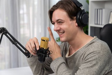 Sunucu kanalı, gülümseyen akıllı yayıncı kaydı, senaryosu ve akıllı telefonuyla sosyal medyada sohbet programı, kulaklık takarak modern ev stüdyosundaki video flamalarını kaydediyor. Bireysel.