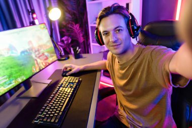 Akıllı oyun flamasının sunucu kanalı kameraya bakarken savaş takımının arka plandaki savaş gemisine silah çekmesini dijital neon siber odada kulaklık takmasını sağlıyor. Bireysel.