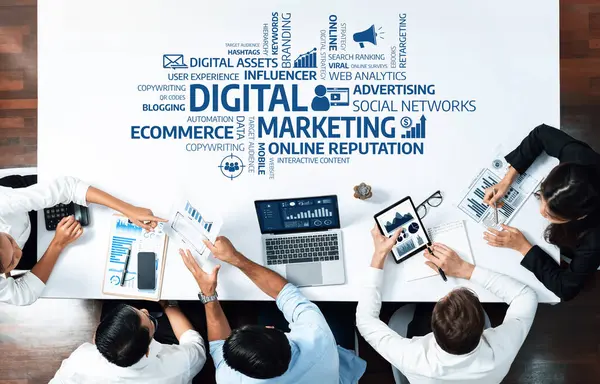 Dijital pazarlama stratejileri üzerinde işbirliği yapan, modern ofis ortamında dizüstü bilgisayar ve grafiklerle veri analizi yapan, katılım ve yeniliği destekleyen çeşitli bir ekibin tepeden tırnağa bir görüntüsü. Dostluk