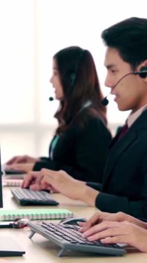 Ofiste çalışan kulaklık takan işadamları uzak müşteri ya da meslektaşlarını desteklemek için çalışıyorlar. Arama merkezi, tele pazarlama, müşteri destek acentesi telefon görüşmesinde hizmet sunar.