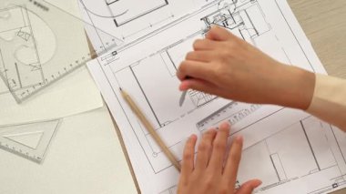 Akıllı mimar ya da akıllı mühendisin ölçüm aracı ve mimari ofisindeki inşaat doğruluğu için plan üzerinde bölücü el yazısı detaylarını kullanmasının videosu. Eline odaklan. - Yakın çekim. Tanımlama.