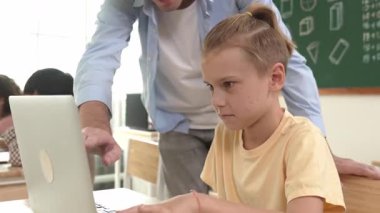 Çeşitli öğrenciler yapay zeka yazılımı kullanırken, Kafkas öğretmeni enerjik çocuğa kodlama konusunda yardım ediyor. Çocuklar oturma ve programlama sistemi. Sevimli bir öğrenci şifreyi öğreniyor. Pedagoji.