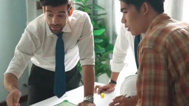 Akıllı iş adamlarının tasarımı planlamak için tabletten proje planına bakarken ve planlar ve toplantı masasındaki bina inşaatı hakkında tartışırken birlikte çalışması. Hizalama.