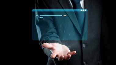 Takım elbiseli bir işadamı, çeşitli programlama dilleri ve kodlama unsurlarını gösteren, teknoloji ve yeniliği sembolize eden holografik bir arayüz sunar. Dörtgen