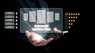 Reytingler ve geri bildirimlerle müşteri memnuniyetinin dijital temsili. Bir el, kullanıcı deneyimi ve duygularının sinyalini veren gülen yüzlerin etkileşimli bir arayüzünü sunar. Dörtgen