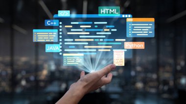 Karanlık bir ofis zeminine kurulmuş, teknoloji ve yenilikleri gösteren çeşitli programlama dilleri ve kod satırlarının parlayan gösterimine uzanan bir el. Auvana