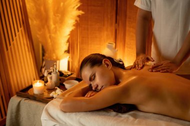 Beyaz kadın müşteri stres önleyici spa masajının keyfini çıkarıyor ve lüks otel ya da otelde sıcak mum ışığında güzellik teniyle eğleniyor. Sessiz.