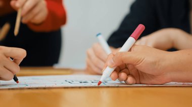 Yetenekli iş adamlarına yakın çekim yapmak beyin fırtınası yapmak, birlikte çalışmak, toplantı masasında zihin haritası ve renkli kalemler kullanarak pazarlama fikrini tartışmak. Eline odaklan. Tertemiz..