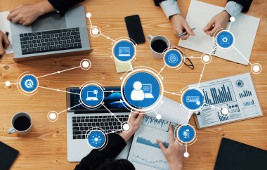 Profesyonel ofis ortamında işbirliği ve veri analizini geliştiren dizüstü bilgisayarlar, çizelgeler ve dijital simgelerin yer aldığı dinamik bir toplantı sahnesi. Dostluk