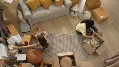 Mutlu online satıcı birlikte çalışıyor ve oturma odasında paket paketliyor. Asyalı girişimci teslimat ürünlerini paketliyor ya da sipariş kutusu göndermeye ya da göndermeye hazırlanıyor. Çevrimiçi iş kavramı. Myrmidon.