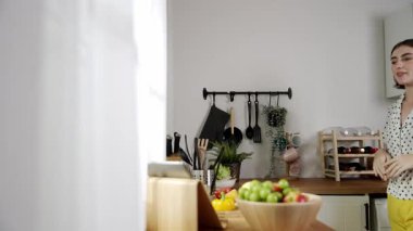 Mutlu genç anne mutfakta dururken salata kasesine sebze koydu. Çekici beyaz bir kadın yemek pişirmekten ve sabah taze organik yemek yapmaktan ya da ev yemeği yapmaktan zevk alır. Pedagoji.