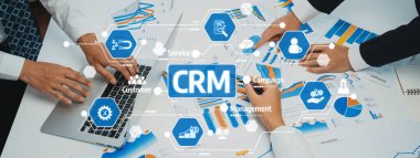 Profesyoneller CRM stratejilerini geliştirmek ve etkili pazarlama girişimleri başlatmak için verileri grafik ve grafiklerle analiz ederken, dinamik bir iş toplantısında takım çalışması sergileniyor. Dostluk