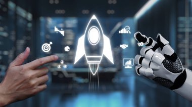 Bir insan eli ve robotik el, modern ofis ortamında yenilik ve teknolojik gelişmeyi sembolize eden roket fırlatma ikonlarıyla etkileşim halindedir. Auvana
