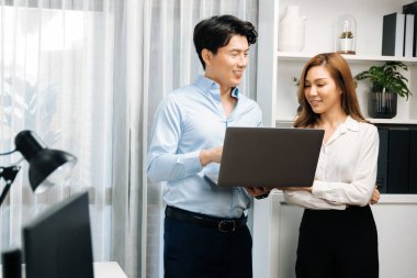 Gülümseyen Asyalı iş arkadaşları modern ofiste dizüstü bilgisayar pazarlama projesi hakkında konuşurken. Yeni sosyal medya kanalında başarılı müşteri ihtiyaçları analiz ediliyor. İnfobahn.