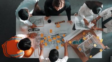 Yetenekli mühendis ekibinin proje planına bakarken konuştuğu en üst seviye görüntü. Birlikte çalışan ve mühendislik inşaatı için plan yapan bir grup akıllı iç mimar. Hizalama.