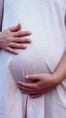 Hamile bir kadın çocuğuna bakarken kendini mutlu hissediyor. Hamile karnında bebek taşıyan hamile bir anne. Doğum öncesi bakım ve kadın hamileliği konsepti.