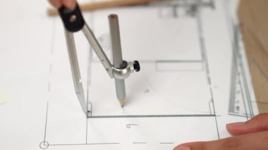 Bölücü araç ve el yazısı kullanan akıllı mimar ya da güvenlik mühendisinin videosu mimari ofisteki inşaat doğruluğu planının ayrıntılarını içeriyor. Eline odaklan. - Yakın çekim. Tanımlama.