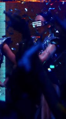 Bir grup insan disko gece kulübünde DJ 'in sahnede çaldığı müzikle dans ediyor. Yeni yıl partisi ve gece hayatı konsepti .