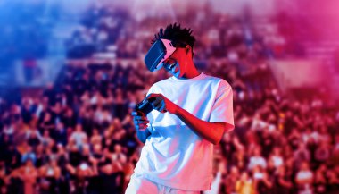 Yetişkinlerin elinde joystickle VR gözlükleri varken stadyumda arka planda bulanık oyunlar oynamaktan zevk alıyorlar. Afrikalı adam kontrol etmeyi ve artırılmış gerçeklik teknolojisini kullanmayı seviyor. Yaratıcılık.